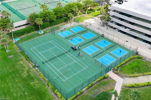 a view of a tennis ground with a white house