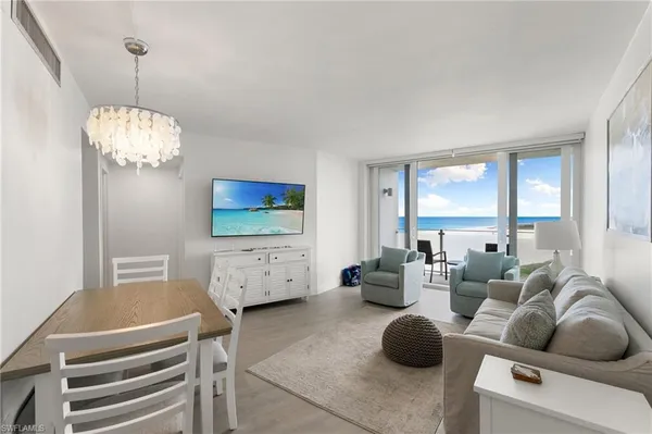 a living room with furniture a chandelier and a flat screen tv