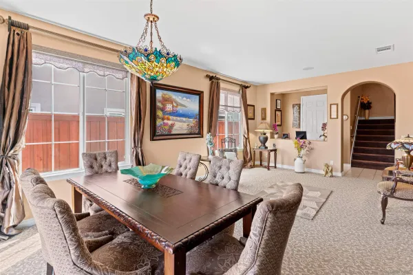 a kitchen with stainless steel appliances granite countertop table chairs sink and cabinets