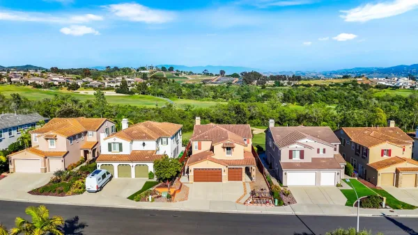 an aerial view of residential houses with outdoor space and swimming pool