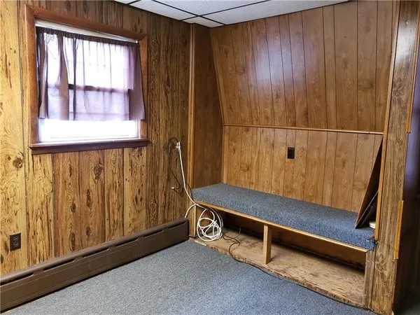 a bench sitting in wooden floor next to a window