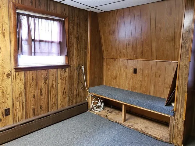 a bench sitting in wooden floor next to a window