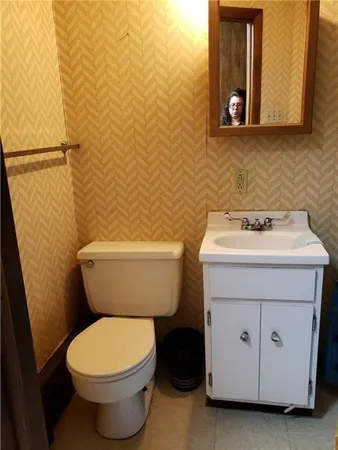 a bathroom with a toilet sink and mirror