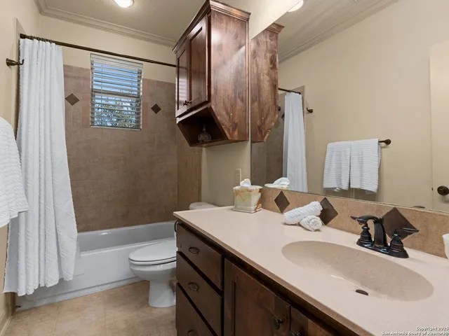 a spacious bedroom with a bed a couch and a chandelier