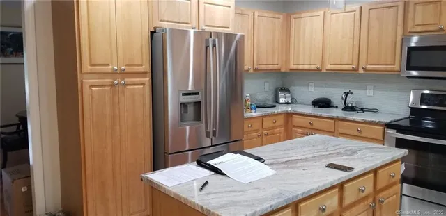 a kitchen with stainless steel appliances granite countertop a refrigerator sink and cabinets