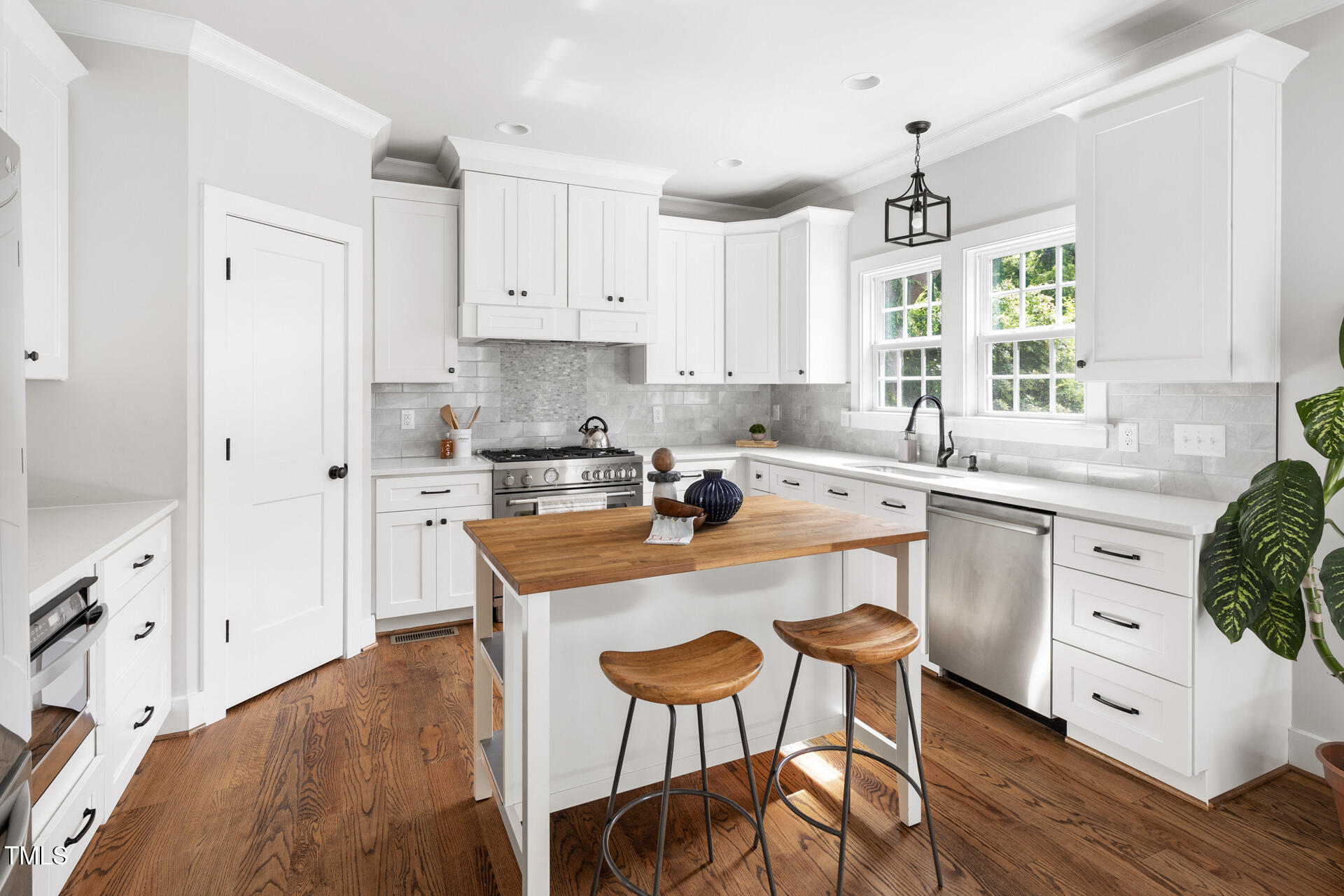 2929 Chapel Hill Road Durham, NC 27707 - Photo 16 of 38 a kitchen with stainless steel appliances granite countertop a white cabinets and wooden floor