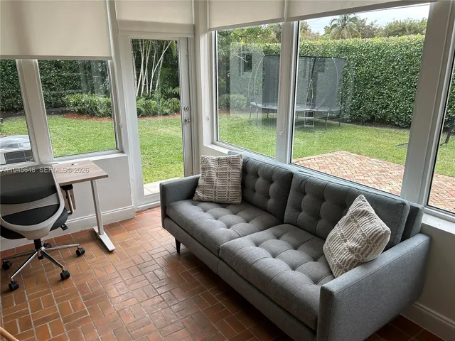 a living room with a couch and a floor to ceiling window