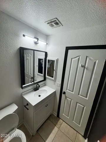 a bathroom with a sink mirror and toilet