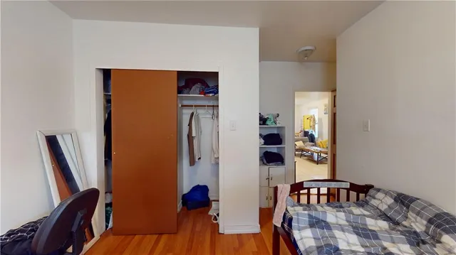 a bedroom with a bed and wooden floor