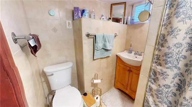 a white toilet sitting next to a sink and a shower curtain