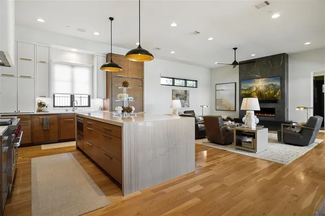 a large kitchen with kitchen island a large counter top space a sink a window and stainless steel appliances