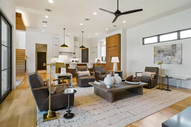 a living room with furniture kitchen view and a large window