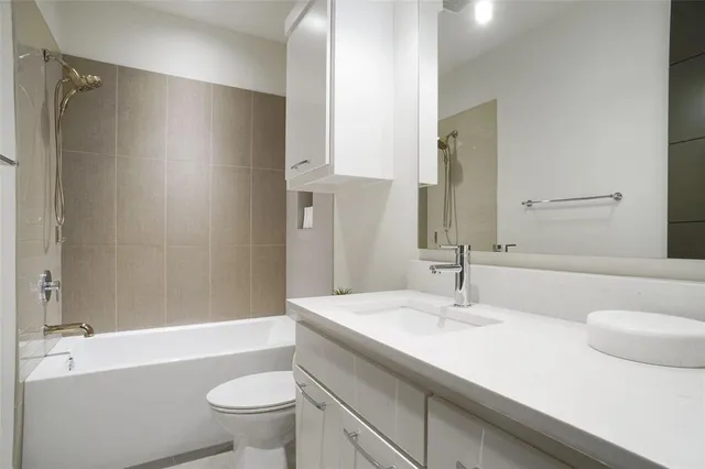 a bathroom with a sink a toilet and a large mirror