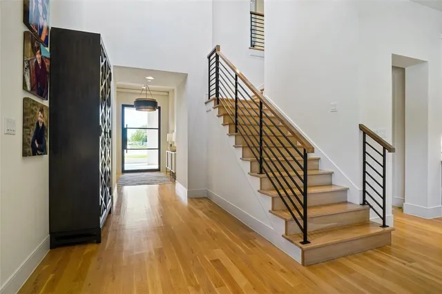 a view of a hallway with wooden floor and staircase