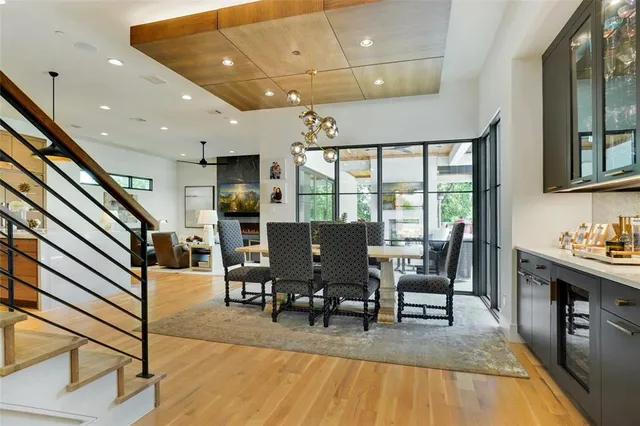 a living room with furniture a large window wooden floor and stainless steel appliances