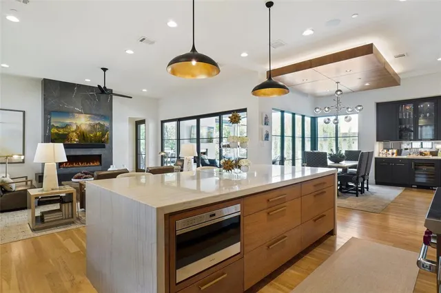 a large kitchen with kitchen island a counter space a sink appliances and a living room view