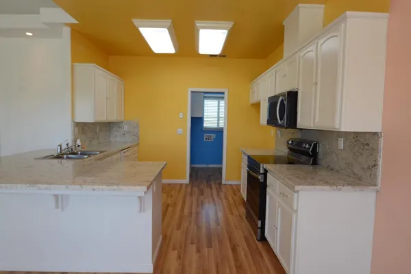 a kitchen with sink a microwave and cabinets