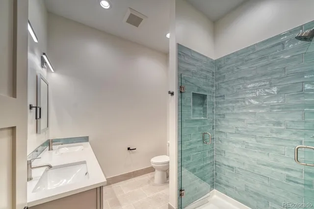 a bathroom with a granite countertop sink toilet and shower