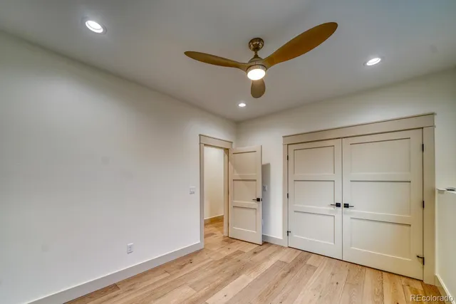 an empty room with closet and a ceiling fan