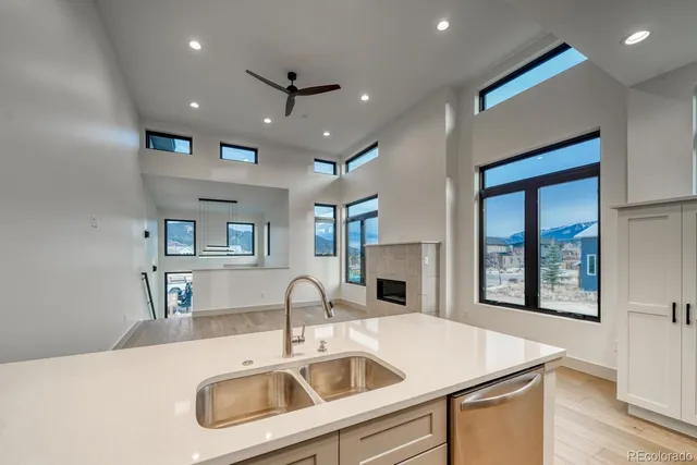 a kitchen with a sink a counter top space and a view of living room