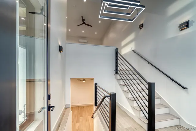 a view of a hallway with wooden floor and staircase