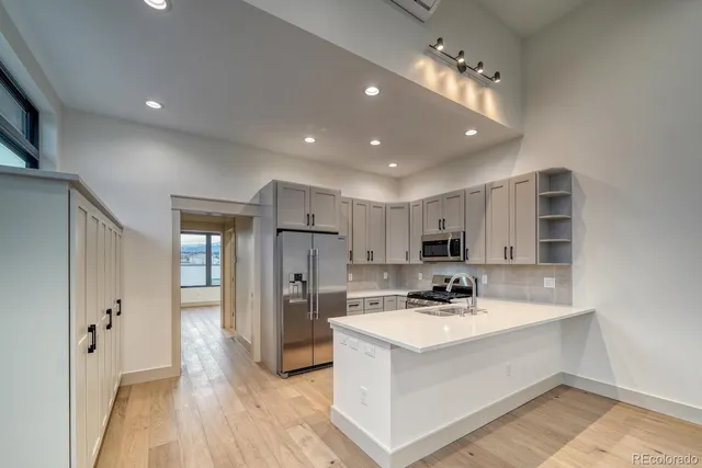 a kitchen with stainless steel appliances a sink a stove a refrigerator and cabinets