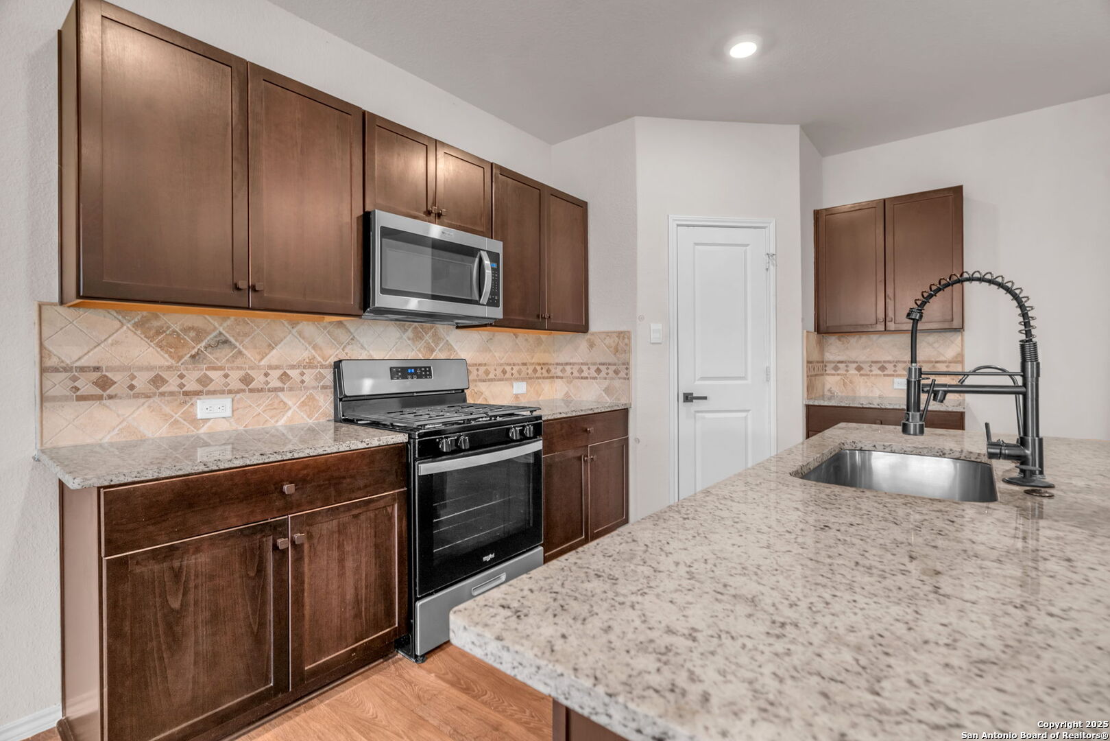 105 Honors Street Floresville, TX 78114 - Photo 11 of 36 a kitchen with sink a stove and refrigerator