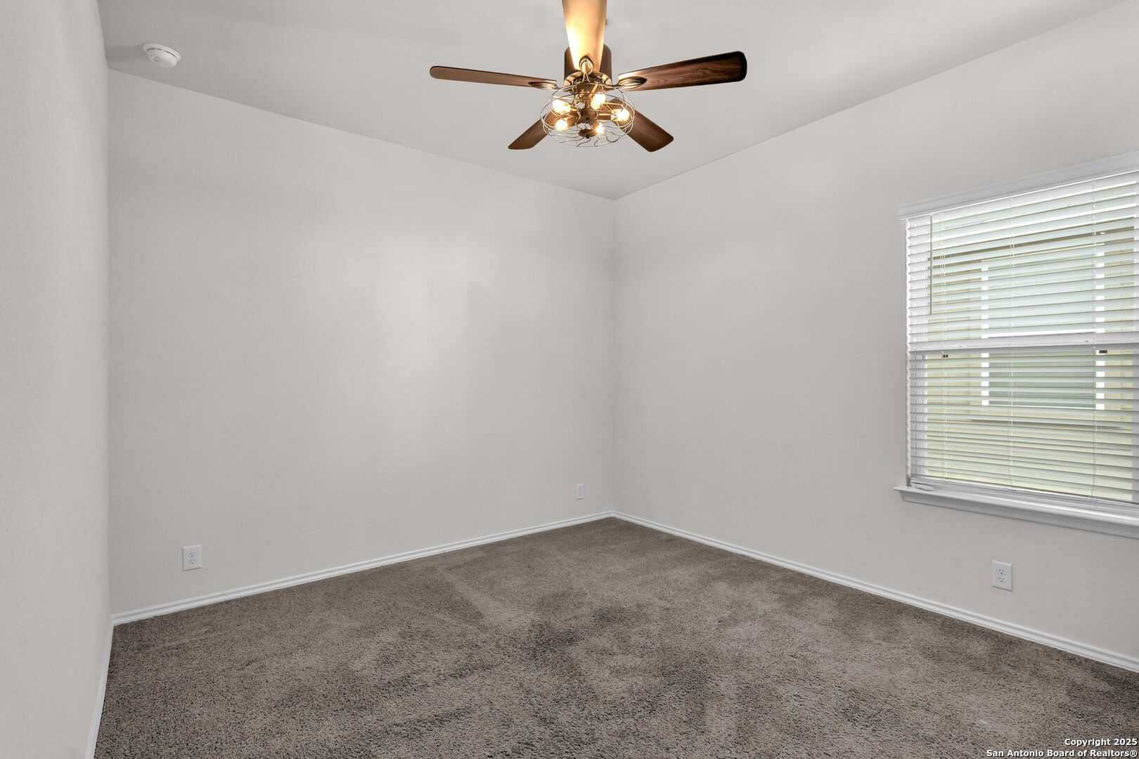 105 Honors Street Floresville, TX 78114 - Photo 14 of 36 an empty room with a window and a fan