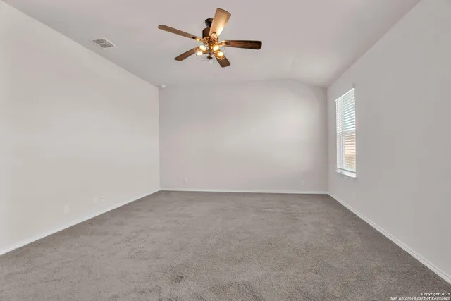 an empty room with a window and a ceiling fan