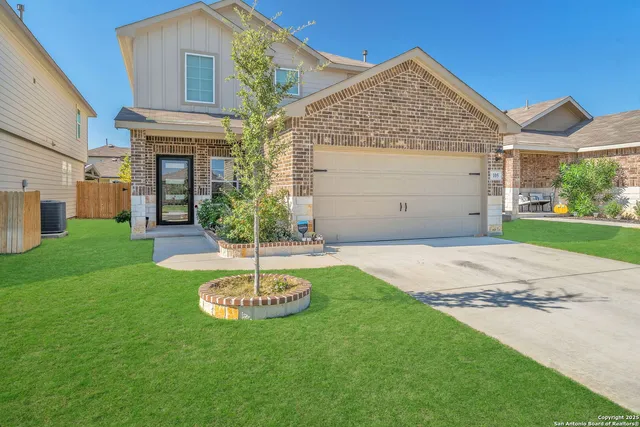 a view of a big house with a big yard and potted plants