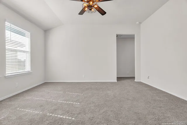 an empty room with a window and a ceiling fan