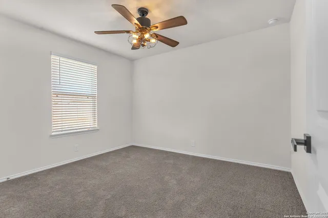 an empty room with a window and a fan