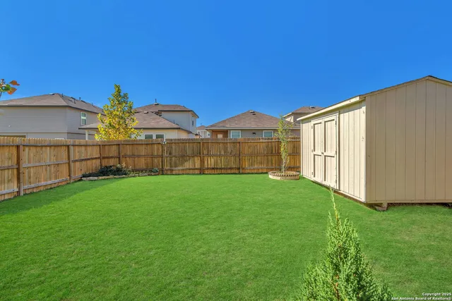 a view of a yard with wooden fence