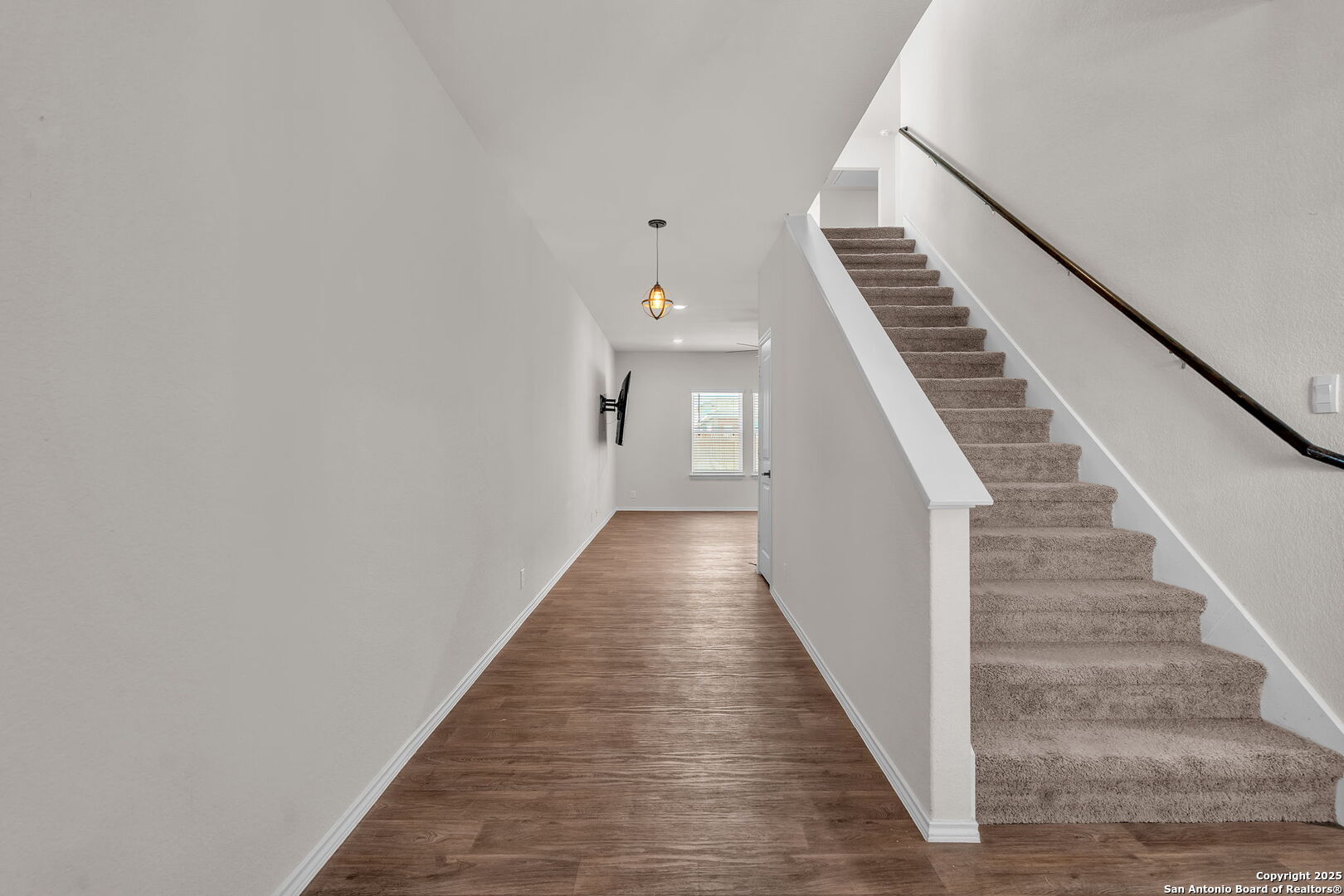 105 Honors Street Floresville, TX 78114 - Photo 5 of 36 a view of staircase with wooden floor and lots of frames on wall