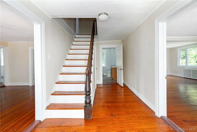 a view of a hallway with wooden floor and entryway