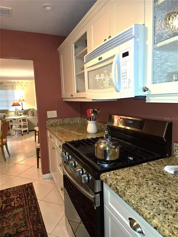 a kitchen with stainless steel appliances granite countertop a refrigerator and a stove