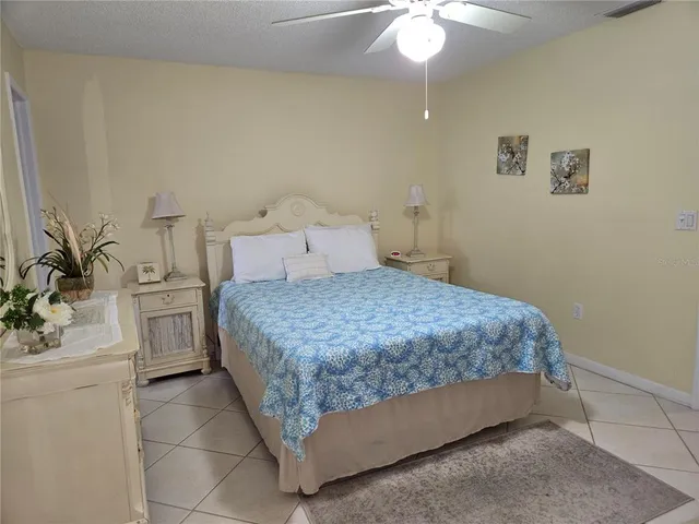 a bedroom with a bed and a refrigerator