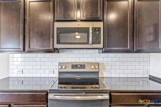 a stove top oven sitting inside of a kitchen