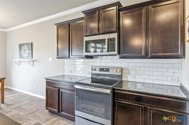 a kitchen with granite countertop cabinets stainless steel appliances and a counter space