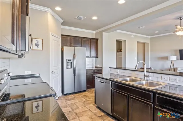 a kitchen with a sink appliances and cabinets