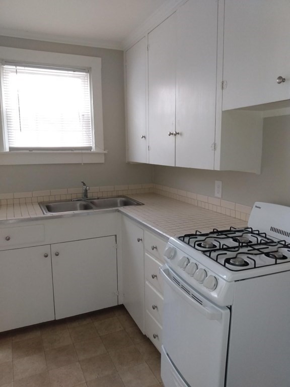 107-121 Winter Street Fall River, MA 02720 - Photo 7 of 10 a kitchen with granite countertop a sink stove and cabinets
