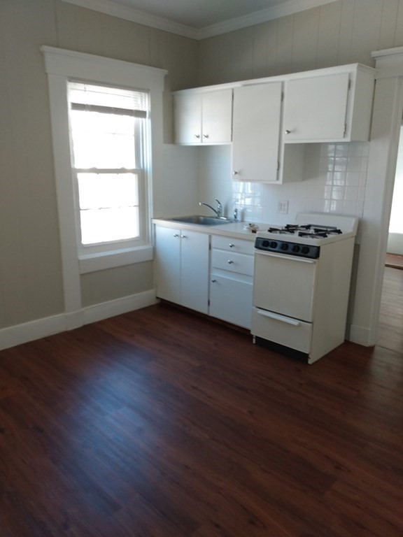 107-121 Winter Street Fall River, MA 02720 - Photo 8 of 10 a kitchen with granite countertop wooden floors and white stainless steel appliances