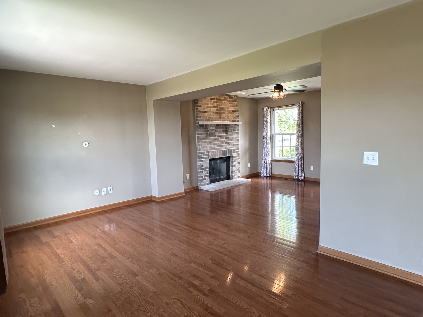811 Water Stone Way Malta, IL 60150 - Photo 13 of 27 an empty room with wooden floor fireplace and windows