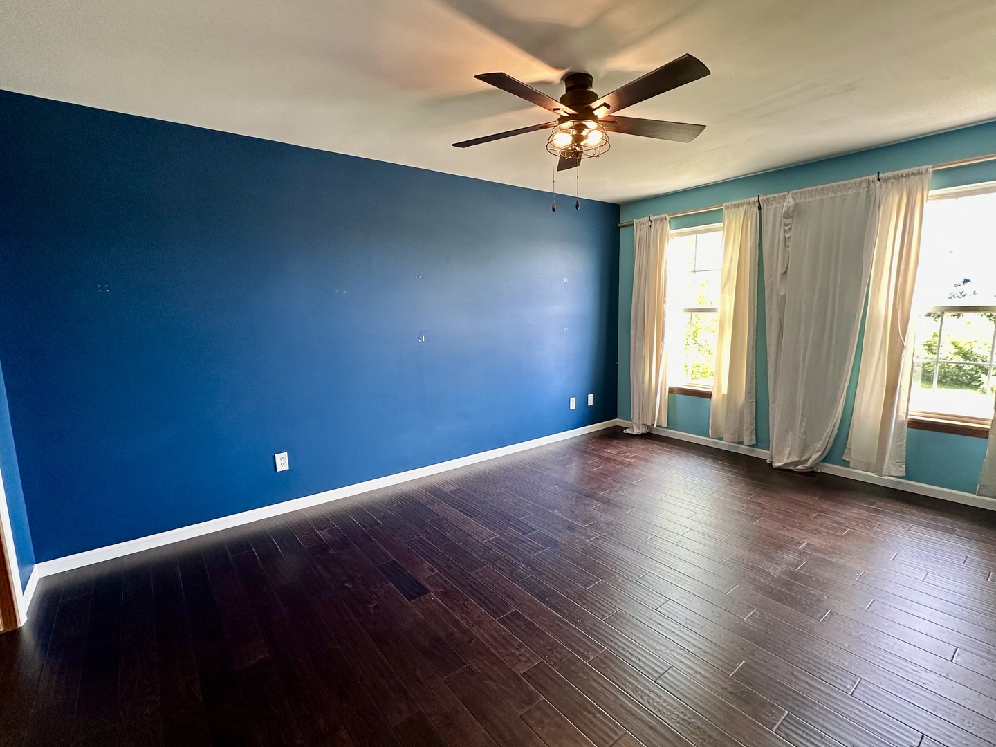 811 Water Stone Way Malta, IL 60150 - Photo 17 of 27 an empty room with wooden floor and windows with curtains