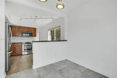 a view of a kitchen with stainless steel appliances cabinets and a window