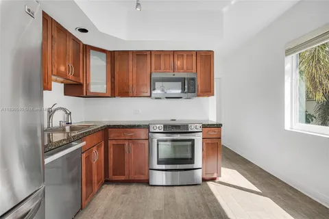a kitchen with stainless steel appliances granite countertop a stove a sink and a microwave