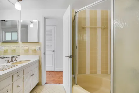 a bathroom with a granite countertop sink a mirror and a shower