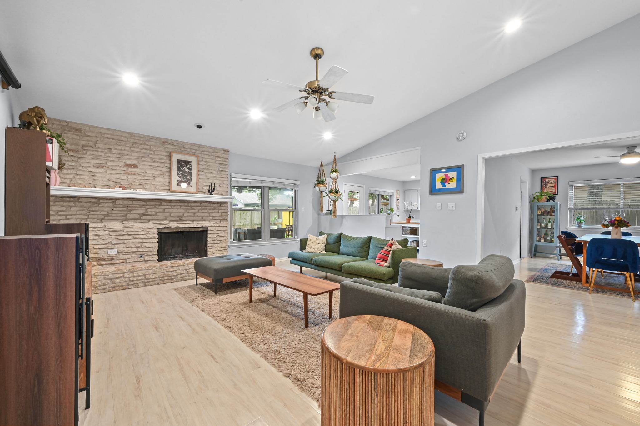 2509 Redleaf Lane Austin, TX 78745 - Photo 4 of 28 Spacious living area featuring a stone-clad fireplace with a white mantel, light wood-finish flooring, recessed lighting, and a ceiling fan