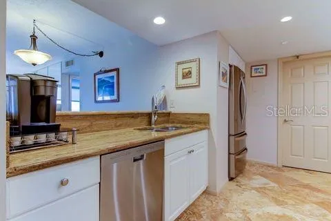 a kitchen with granite countertop white cabinets and stainless steel appliances