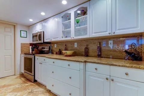 a kitchen with granite countertop a sink and white cabinets
